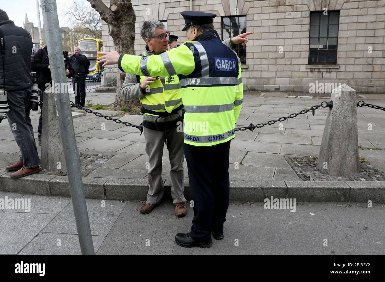 A member of An Garda speaks with a supporter of Gemma O'Doherty and John Waters who have launched a legal challenge against the State over emergency laws and restrictions introduced to stop the spread of Covid-19 outside the High Court in Dublin. Stock Photo