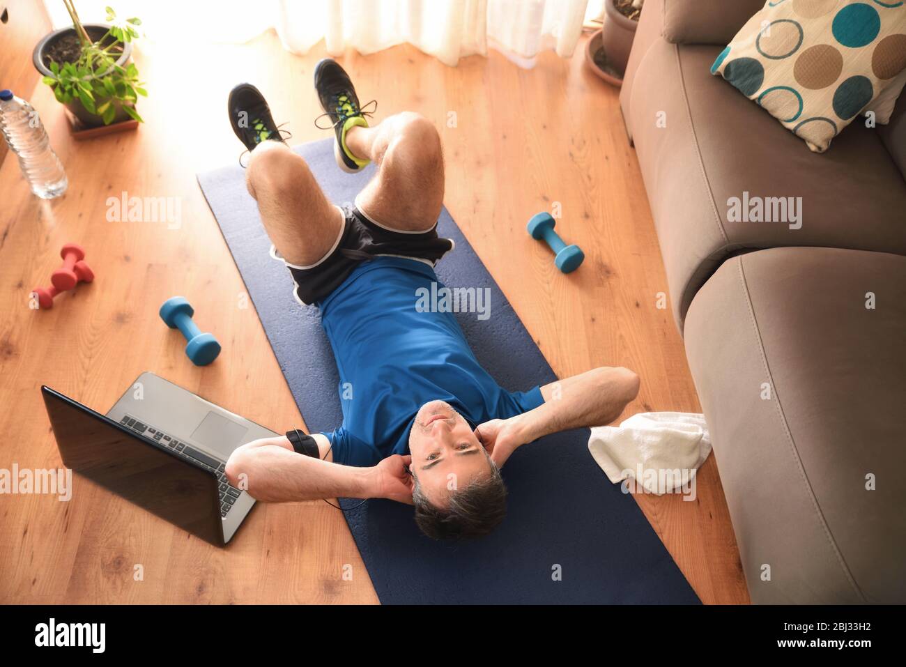 Man doing abdominal and leg exercises in the living room at home lying down on a mat top view Stock Photo Alamy