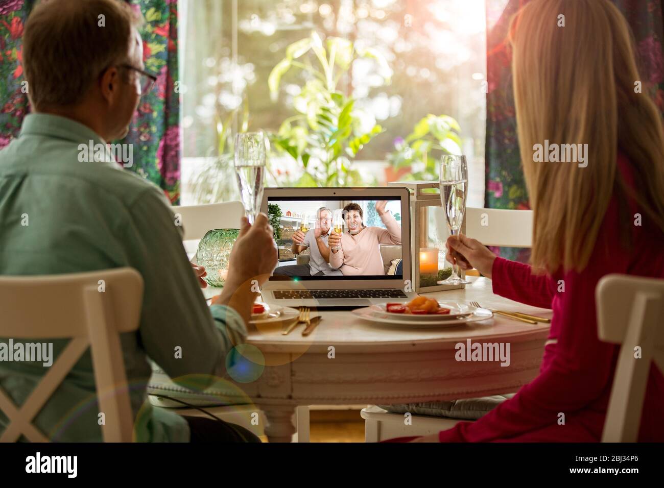 Video Call Dinner Man and woman sitting at the dining table, having dinner, drinking ...
