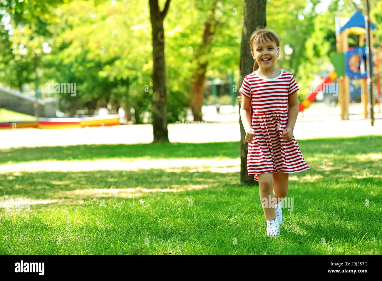 Little happy girl playing in park near the playground Stock Photo - Alamy