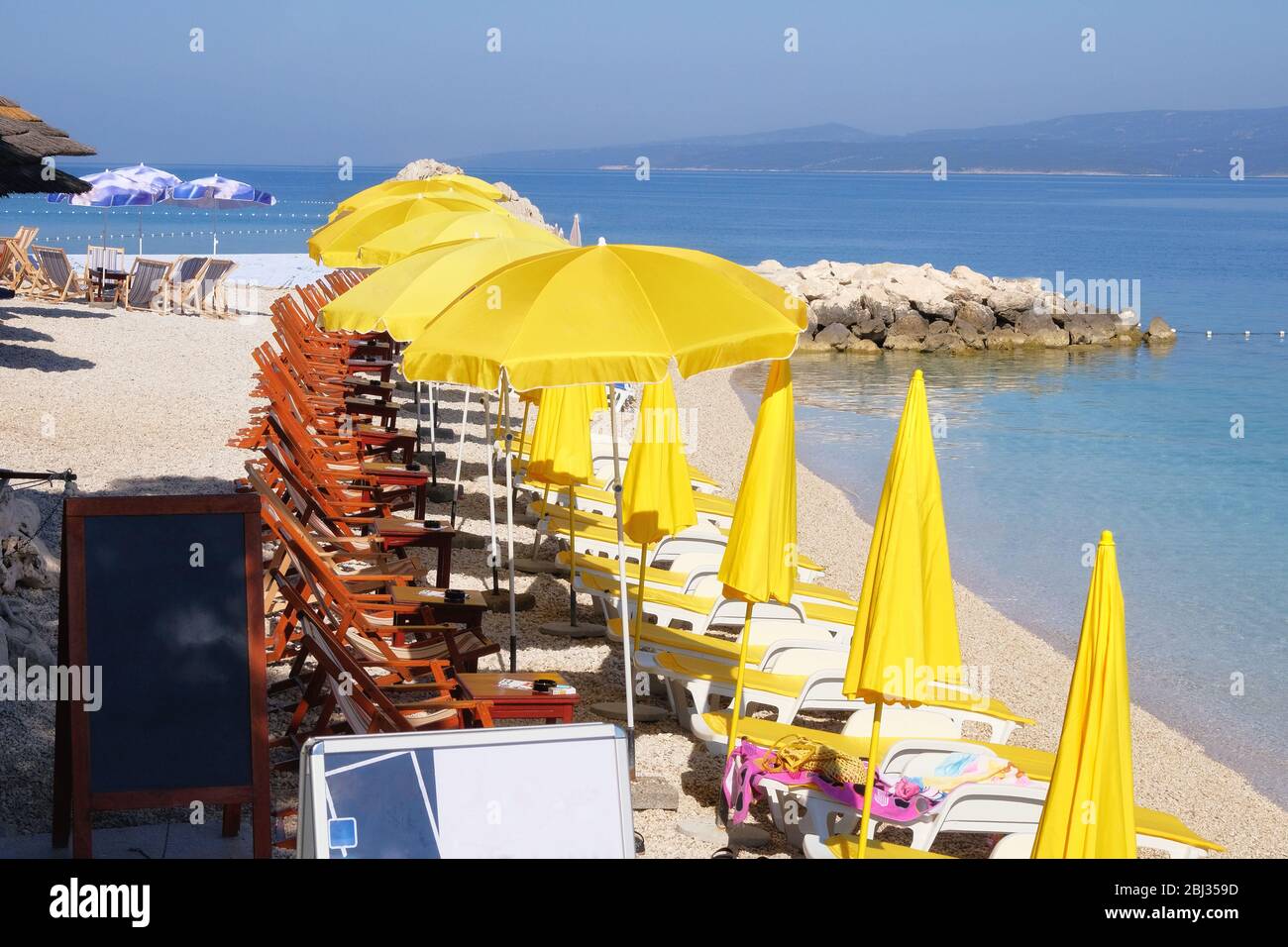 Beach yellow umbrellas and chaise for relax and comfort on sea coast