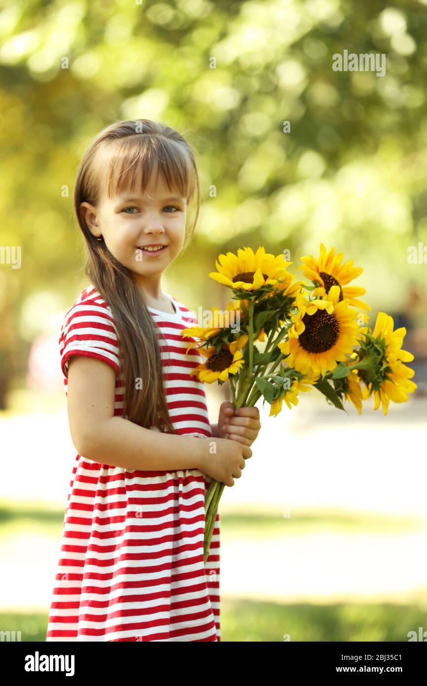 Little girl with sunflowers in the park Stock Photo - Alamy
