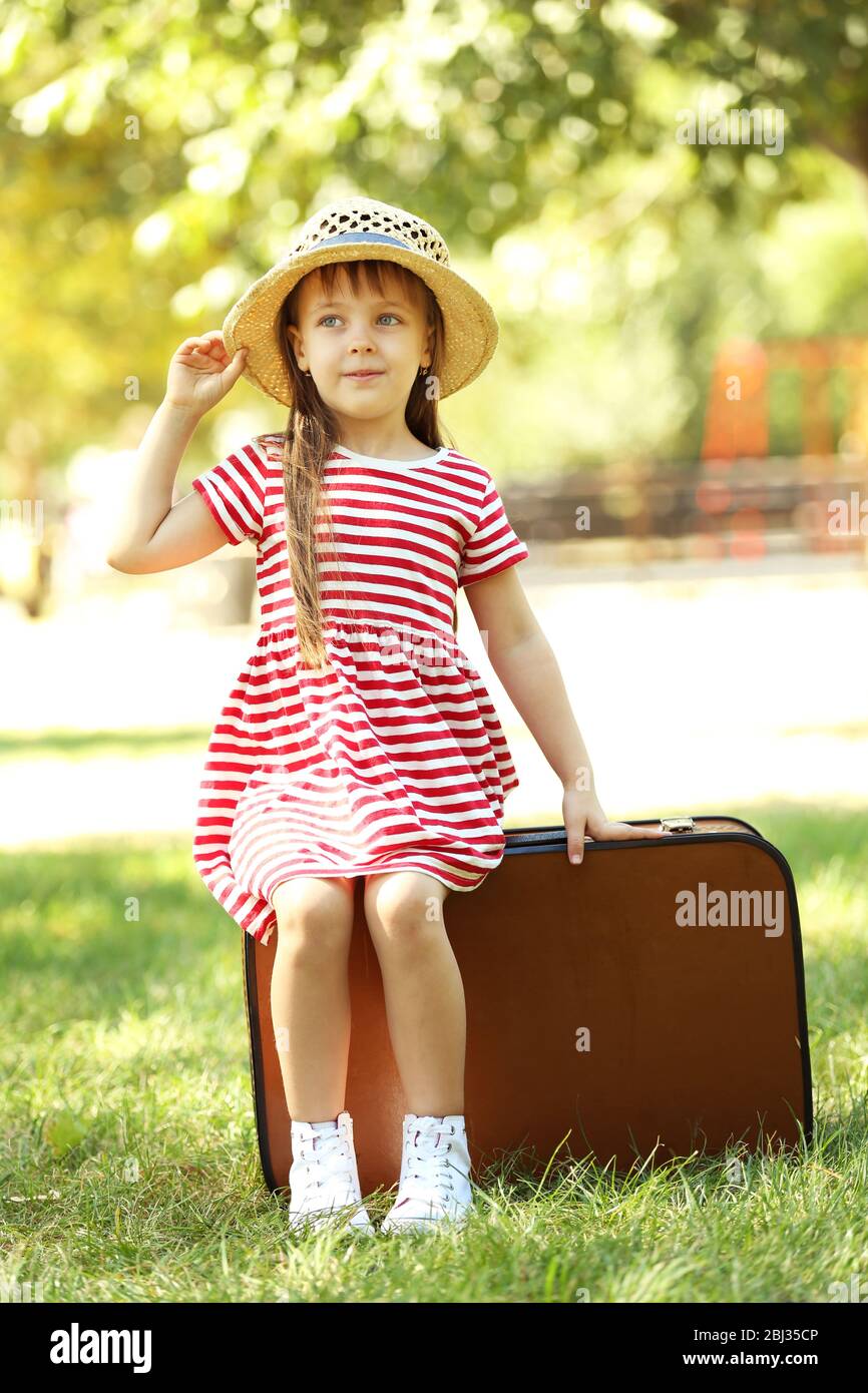 Little girl with suitcase in the park Stock Photo Alamy