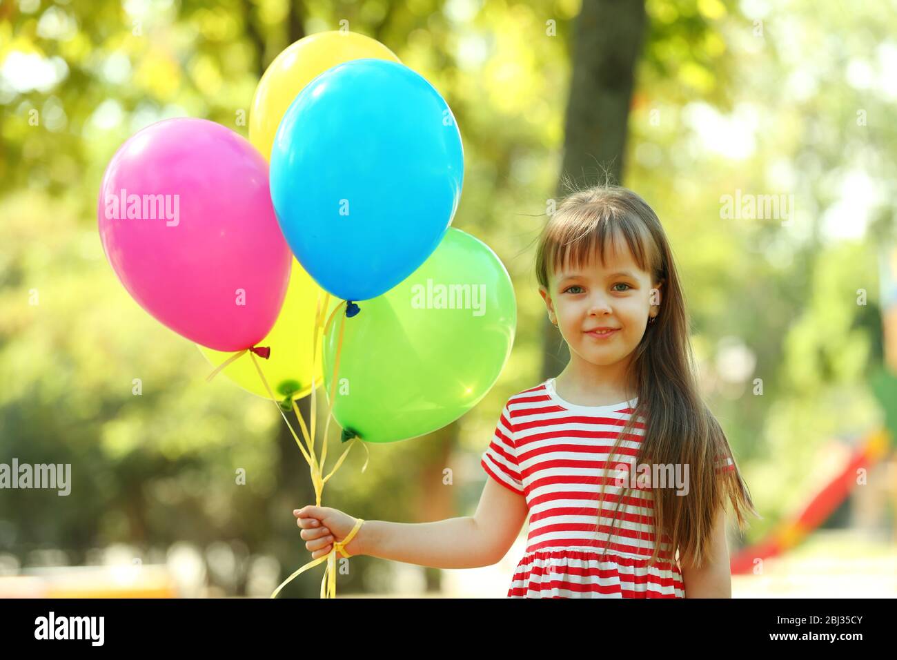 Little girl with balloons in the park Stock Photo - Alamy
