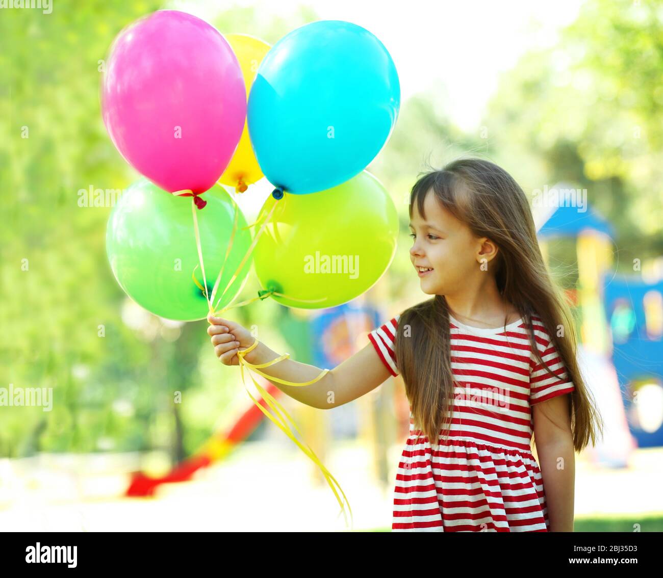 Little girl with balloons in the park Stock Photo - Alamy