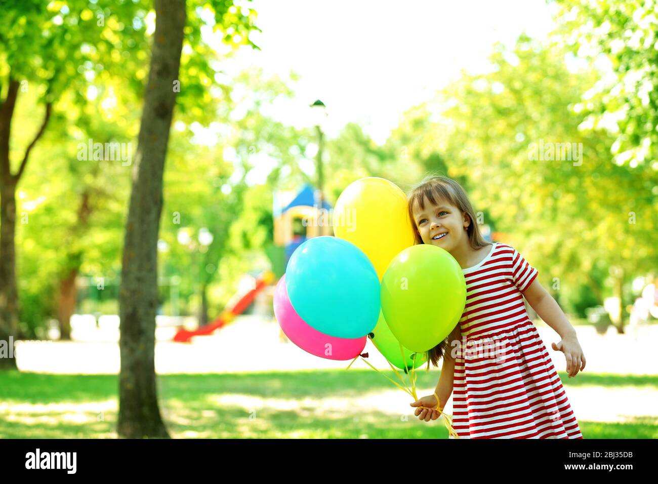 Little girl with balloons in the park Stock Photo - Alamy
