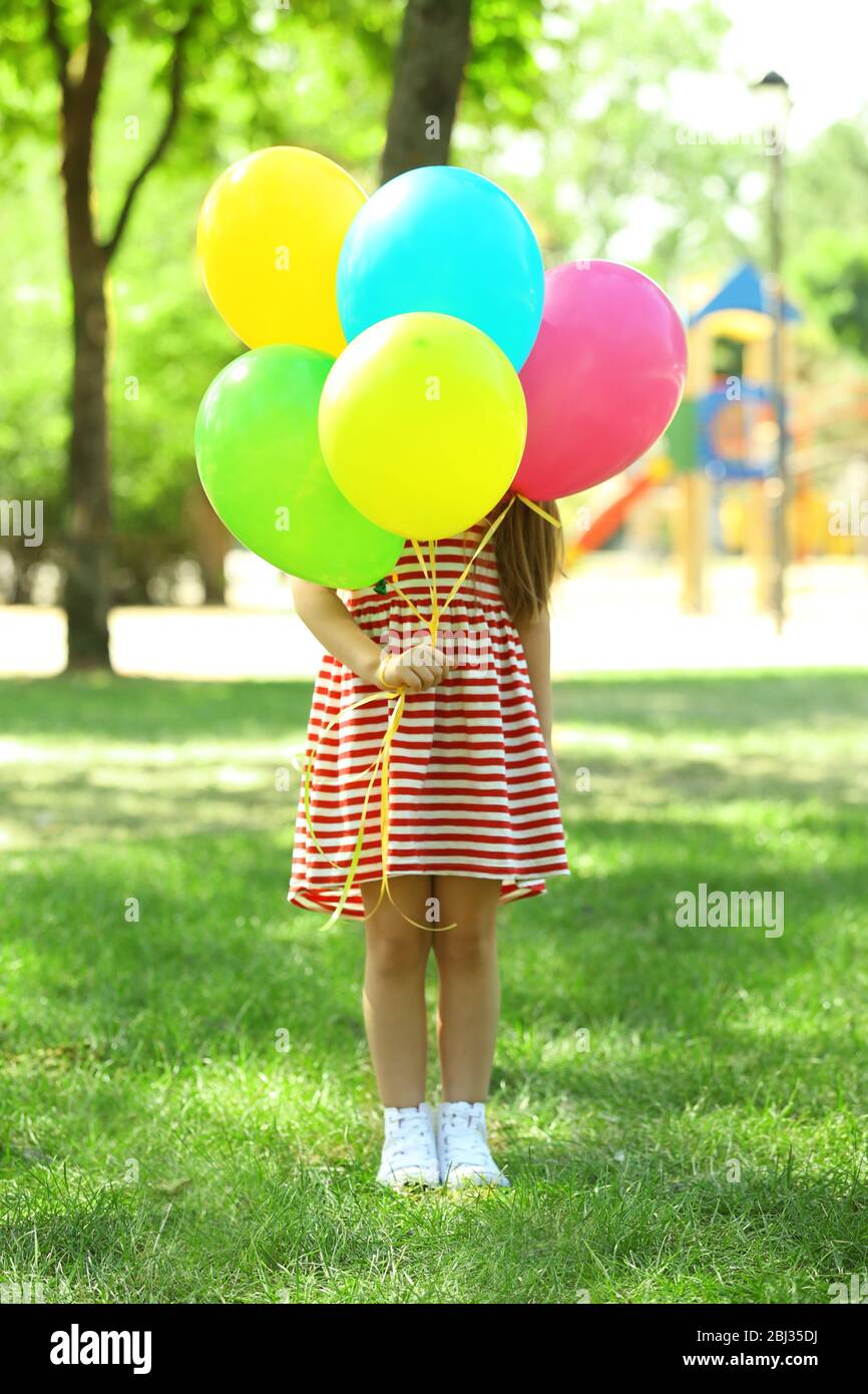 Little girl with balloons in the park Stock Photo - Alamy