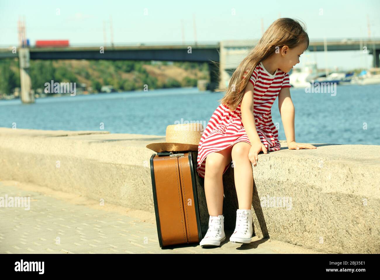 Little girl with suitcase on the riverside Stock Photo Alamy