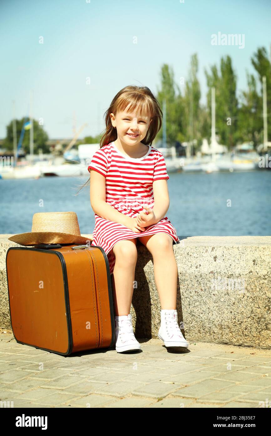 Little girl with suitcase on the riverside Stock Photo Alamy