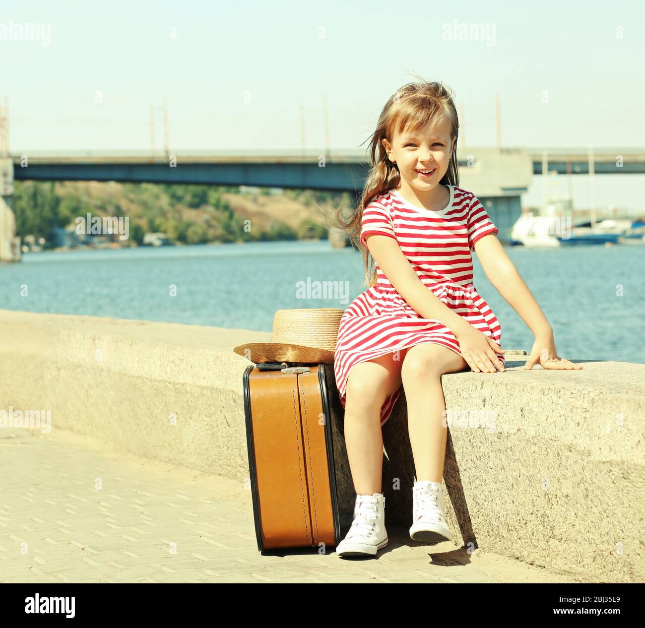 Little girl with suitcase on the riverside Stock Photo Alamy