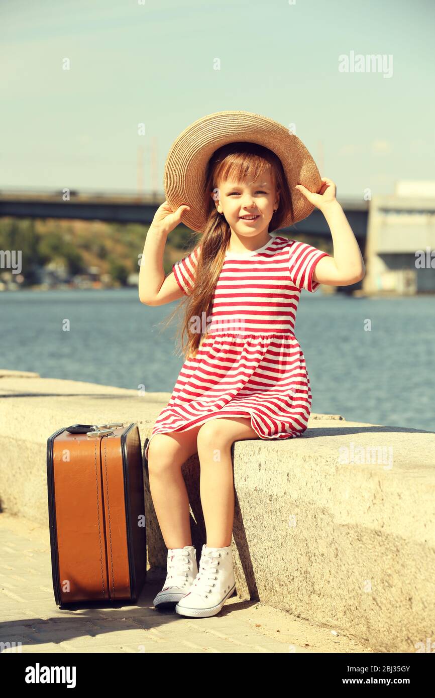 Little girl with suitcase on the riverside Stock Photo Alamy