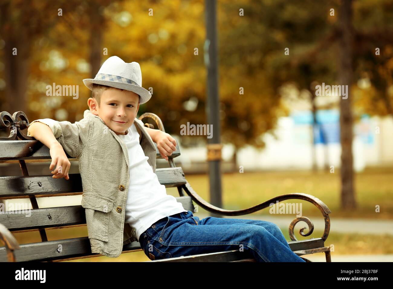 Little boy on bench in the park Stock Photo - Alamy