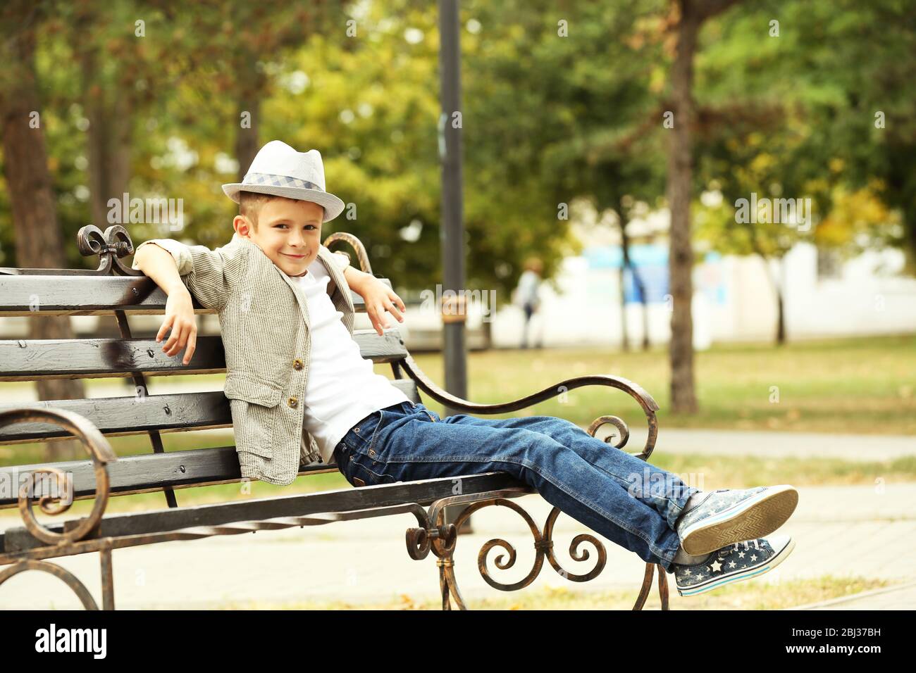 Little boy on bench in the park Stock Photo - Alamy