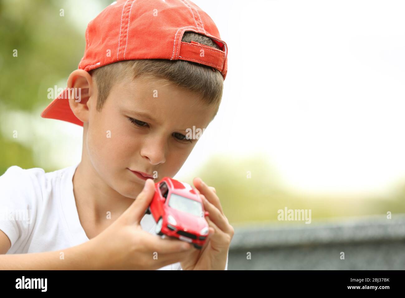 Little boy playing with toy car outside Stock Photo - Alamy
