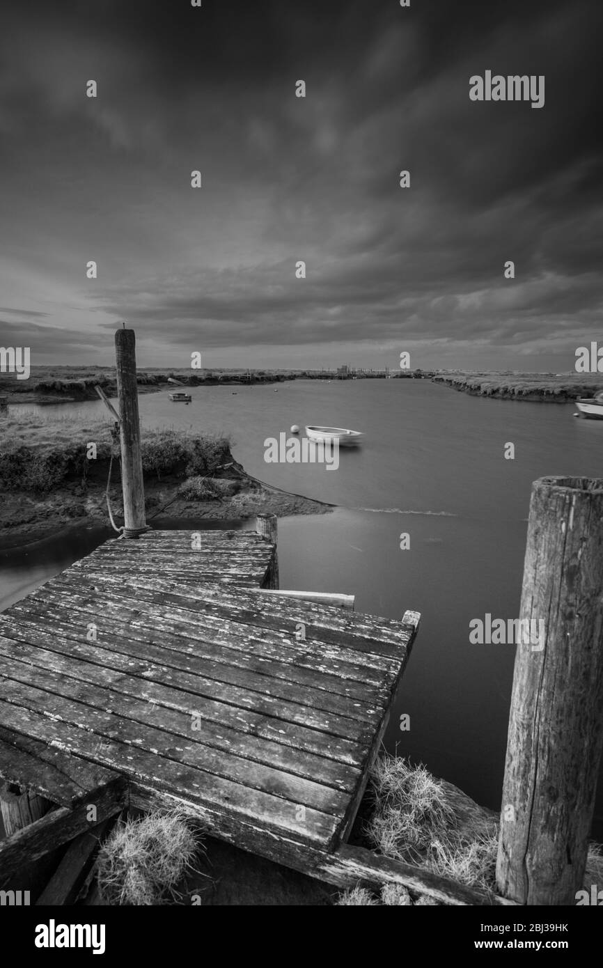 Jetty and mooring posts at Morston Quay, Norfolk, England. Black and white infra red image. Stock Photo