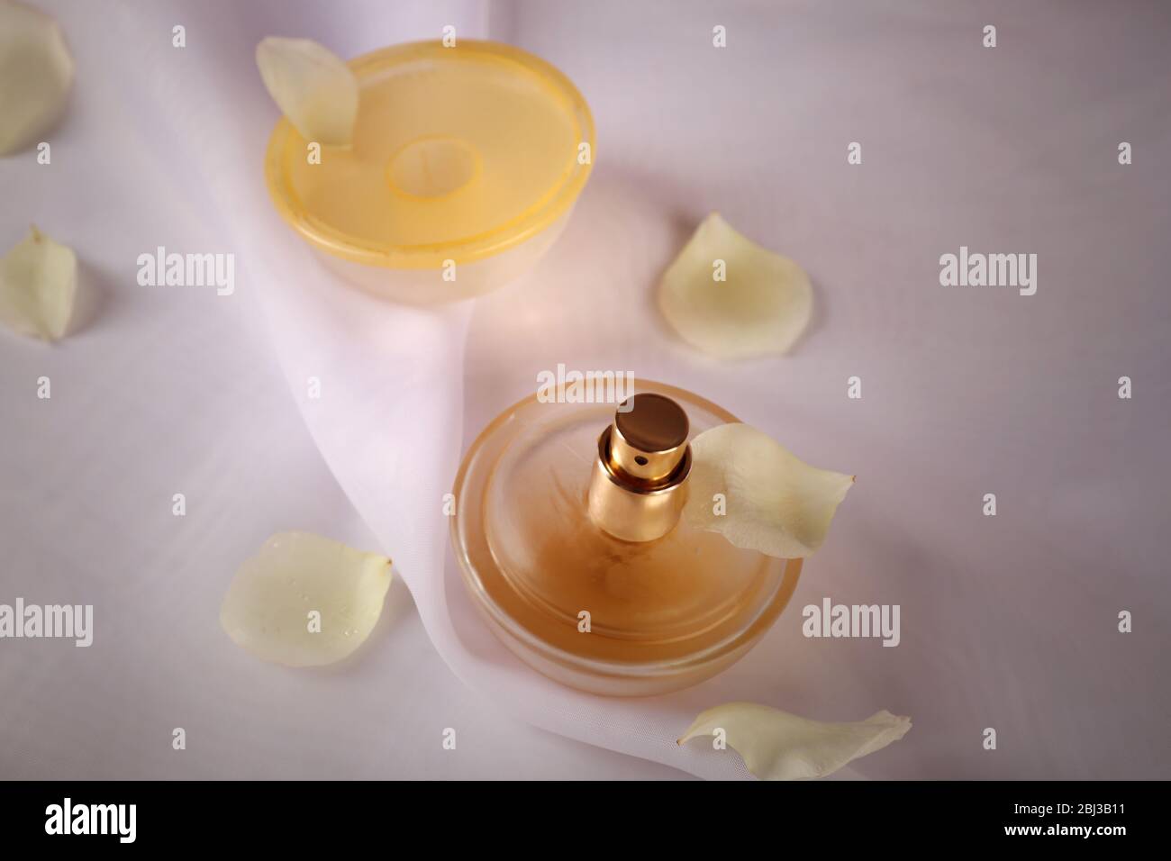 Bottle of perfume and rose petals on fabric background Stock Photo - Alamy
