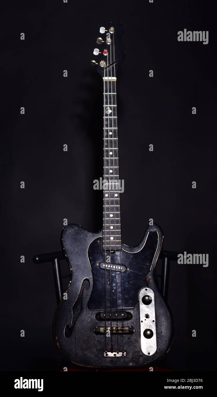 Guitar in deep black color on black background. Musical instrument with