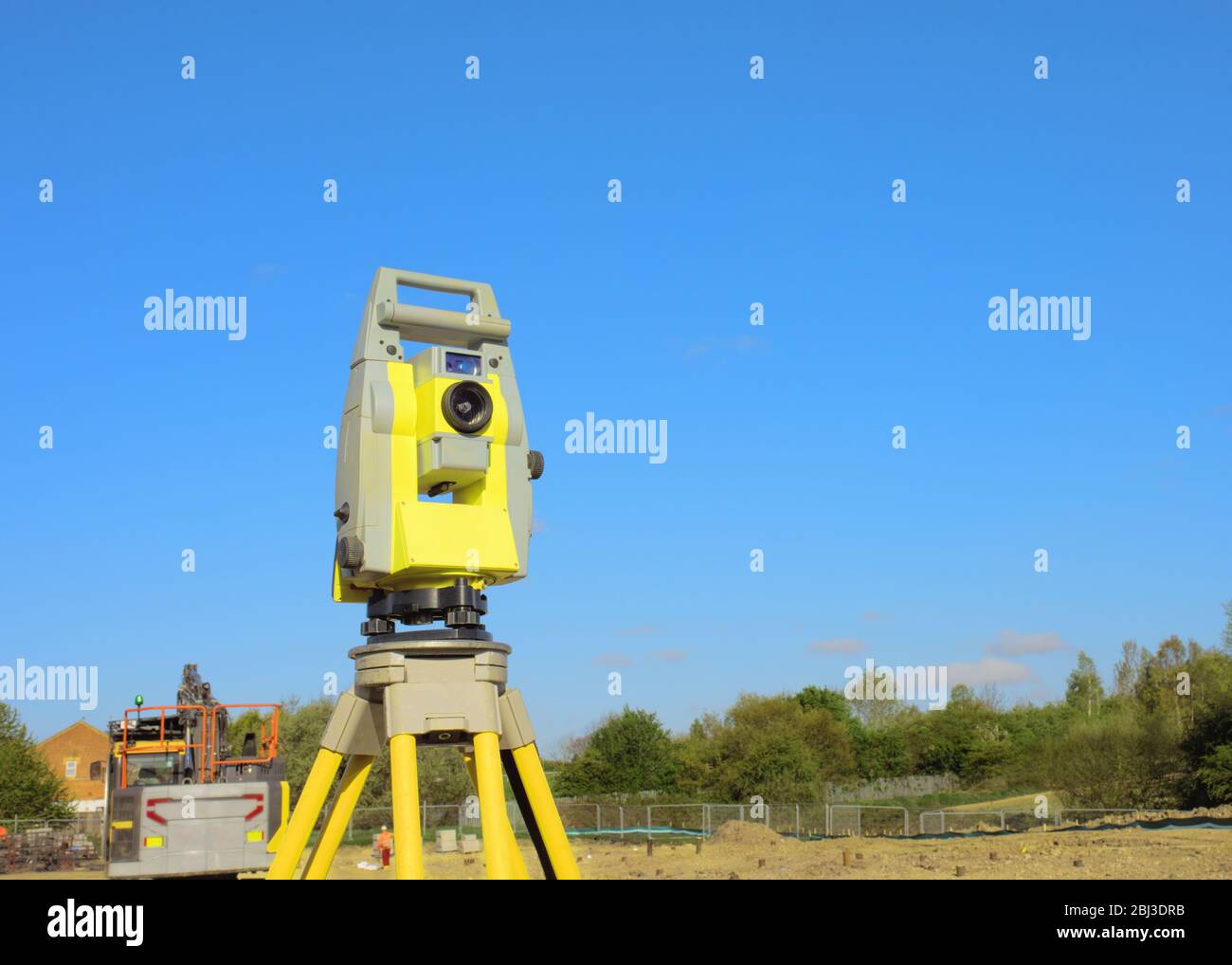 Yellow equipment set out on tripod on building site against a cloudless ...