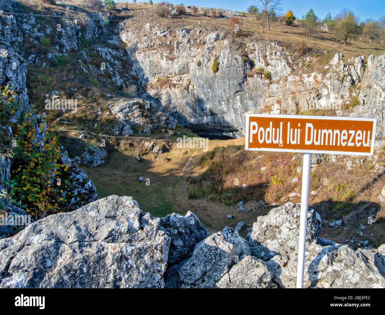 A sign indicating God's Bridge (Podul lui Dumnezeu), a natural bridge  created by the colapse of a cave, a famous tourist attraction in Ponoarele,  Roma Stock Photo - Alamy