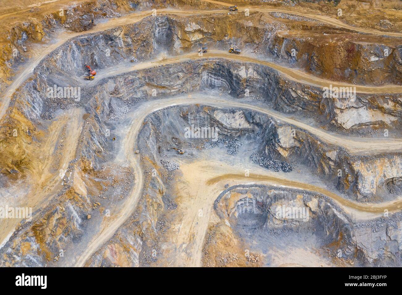 Mining from above. Industrial terraces on open pit  mineral mine. Aerial view of opencast mining. Dolomite Mine Excavation. Extractive industry. Giant - Stock Image