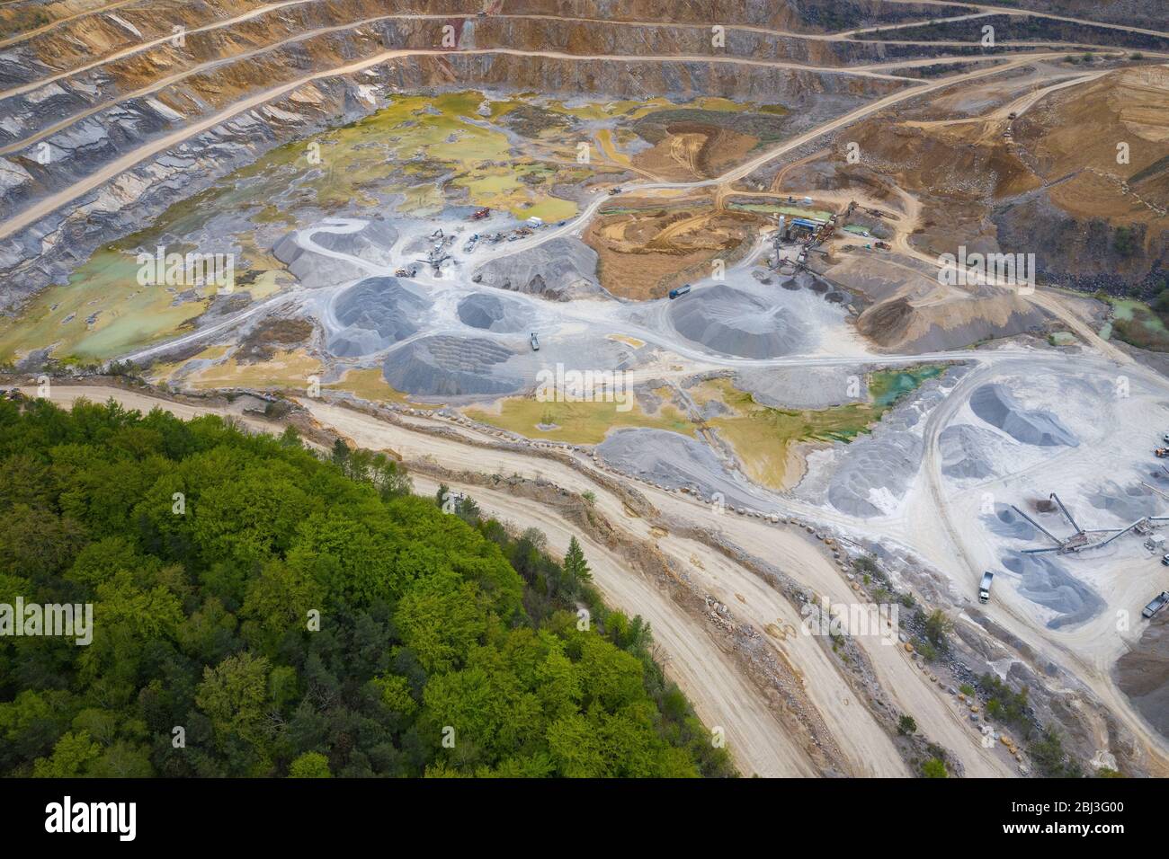 Mining from above. Industrial terraces on open pit  mineral mine. Aerial view of opencast mining. Dolomite Mine Excavation. Extractive industry. Giant Stock Photo