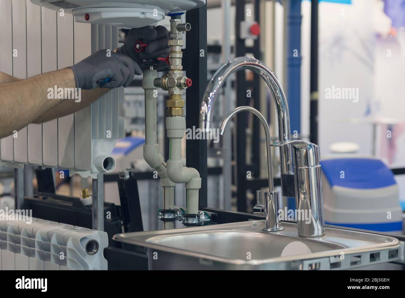 Hands of professional Plumber with a water tap and wrench. Sanitary work Stock Photo