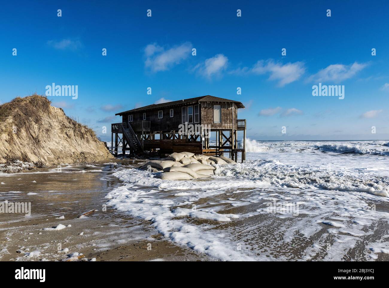 Nags Head beach house on stilts surrounded by high tide storm surf. Stock Photo