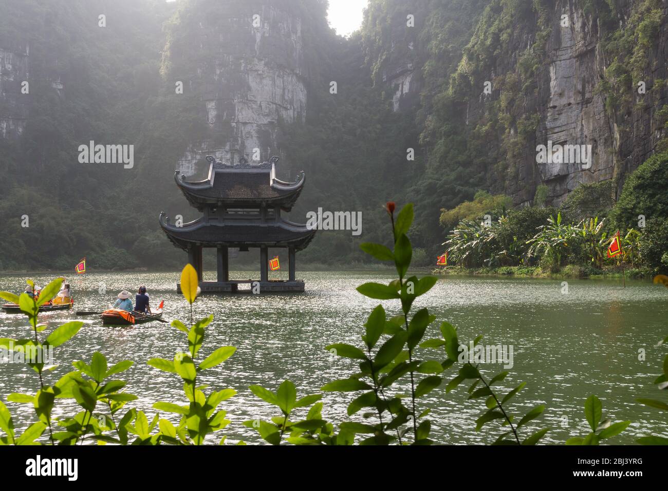 Vietnam Trang An Landscape - A floating temple in Trang An in the Red River Delta in Ninh Binh Province of North Vietnam, Southeast Asia. Stock Photo