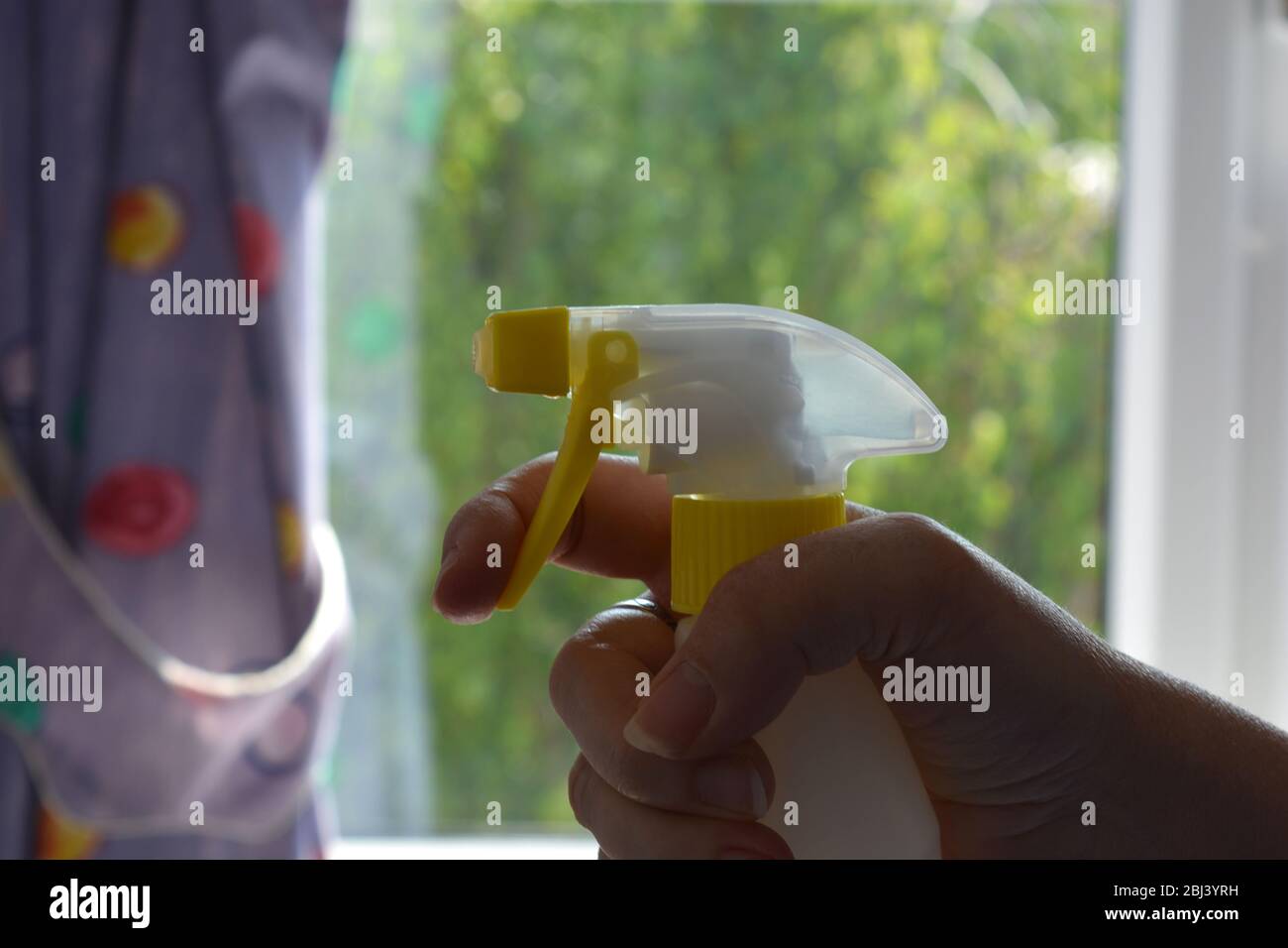 Hand holding spray bottle, spring cleaning Stock Photo