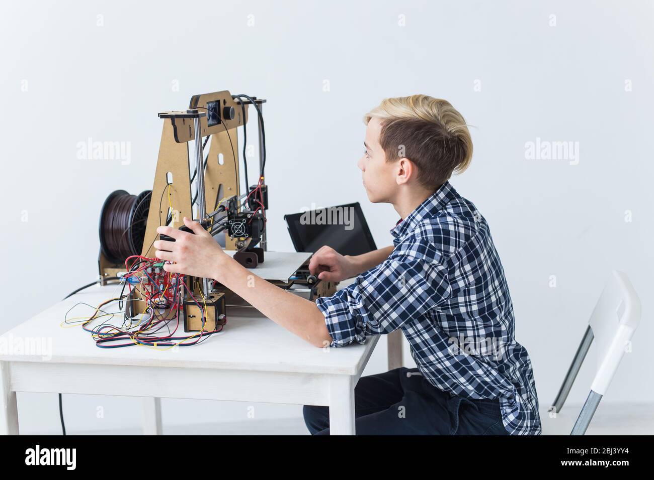Education, children, technology concept - teen boy is printing on 3d ...