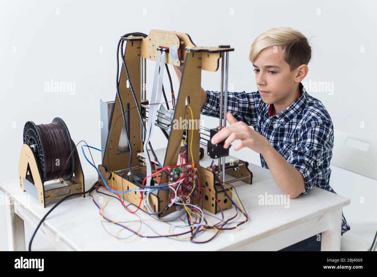 Education, children, technology concept - teen boy is printing on 3d ...