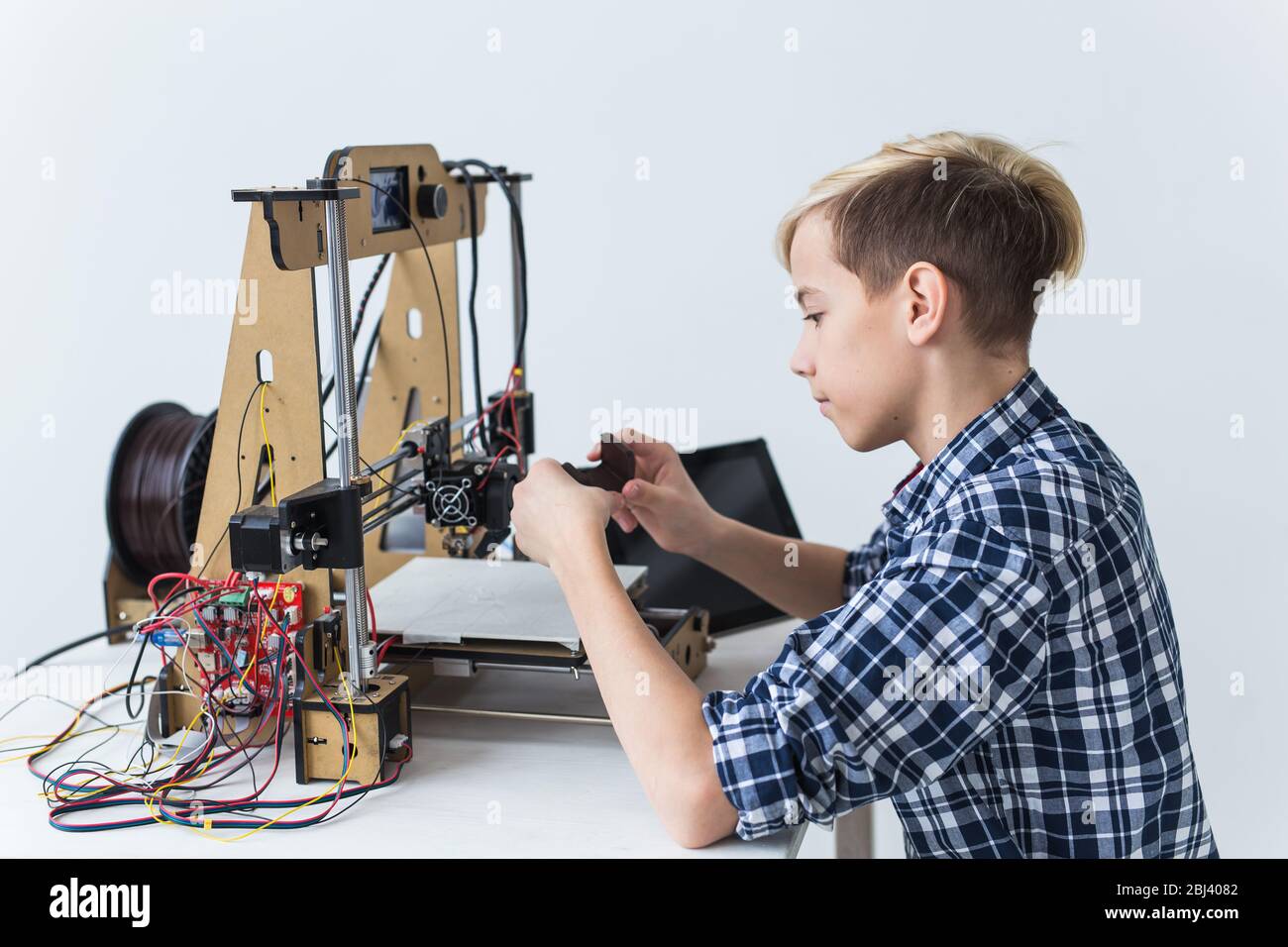Education, children, technology concept - teen boy is printing on 3d ...