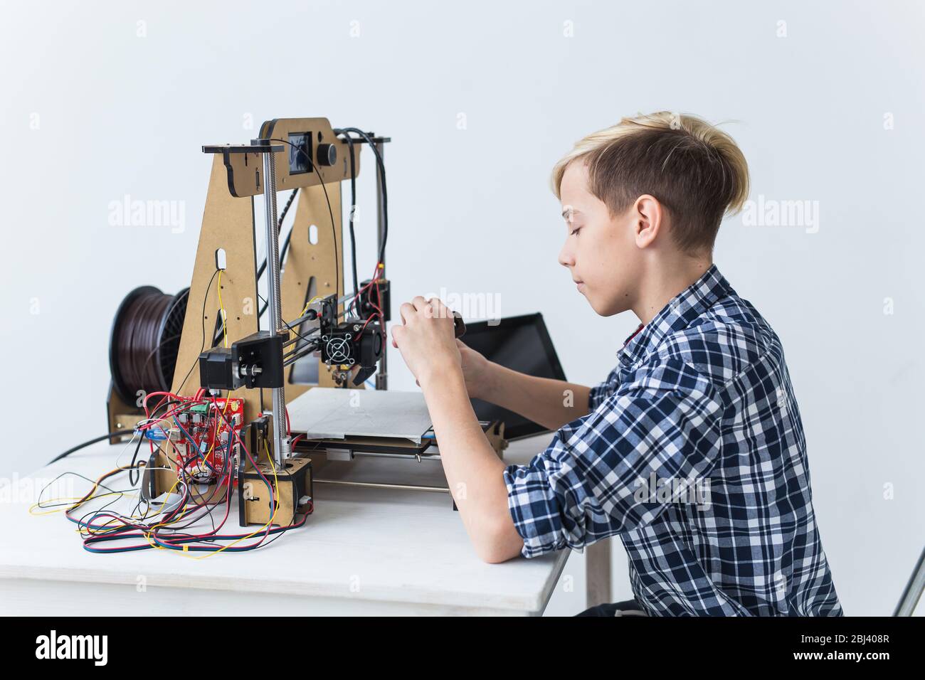 Education, children, technology concept - teen boy is printing on 3d ...