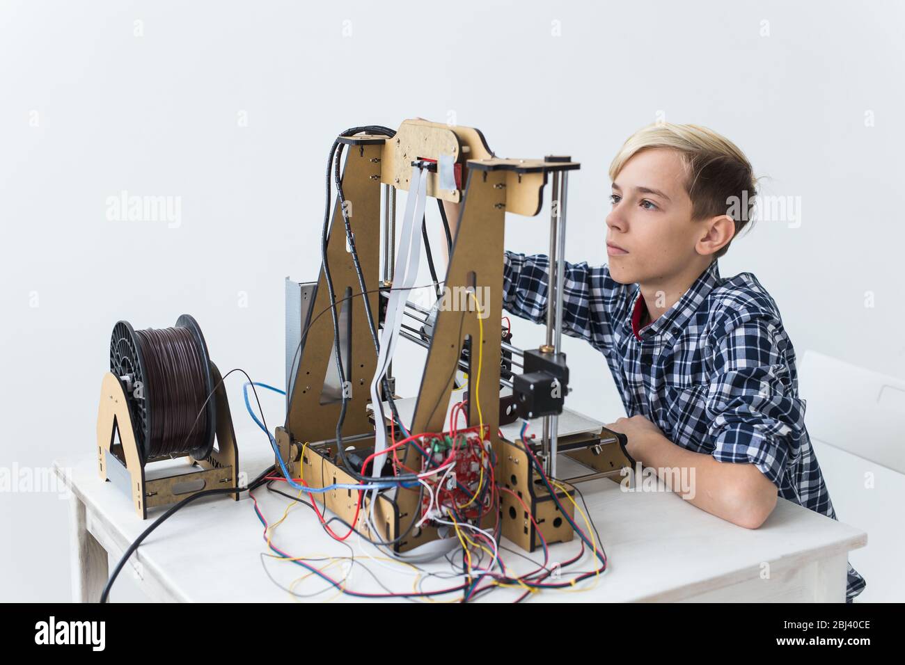 Education, children, technology concept - teen boy is printing on 3d ...