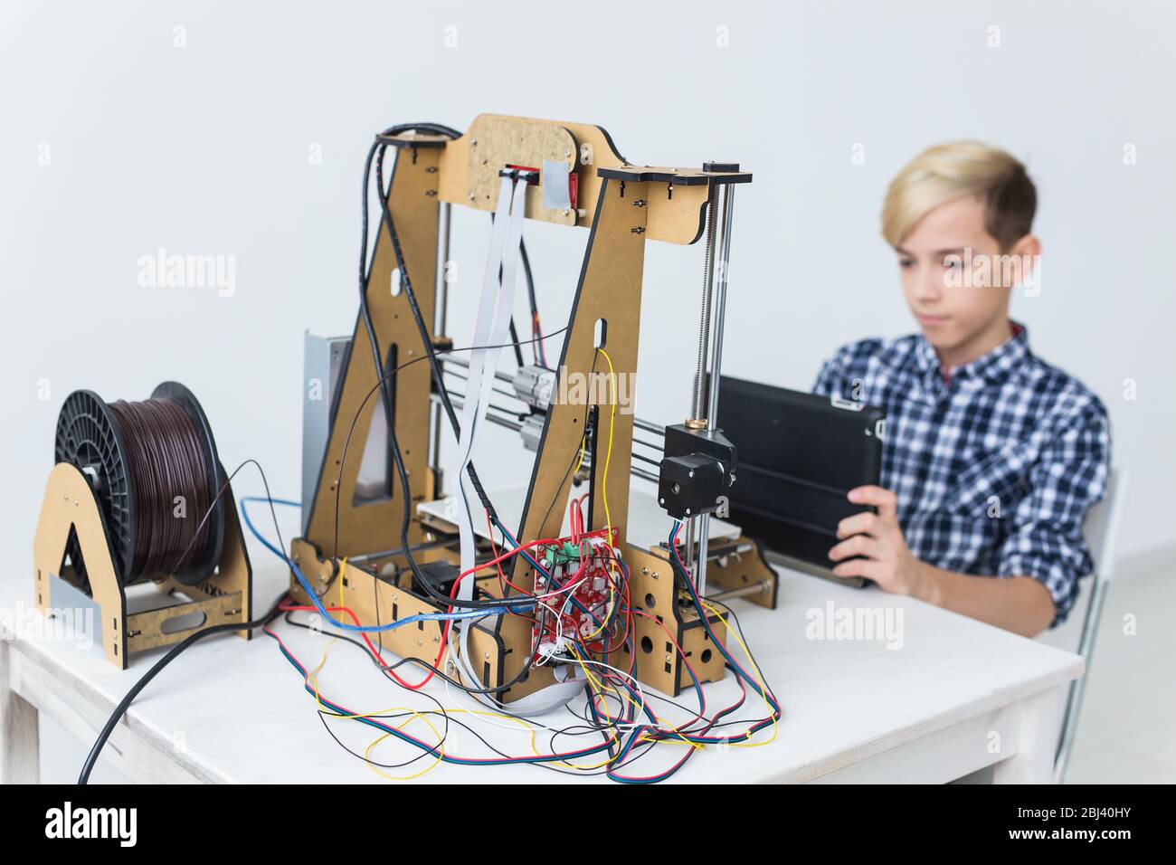 Education, children, technology concept - teen boy is printing on 3d ...