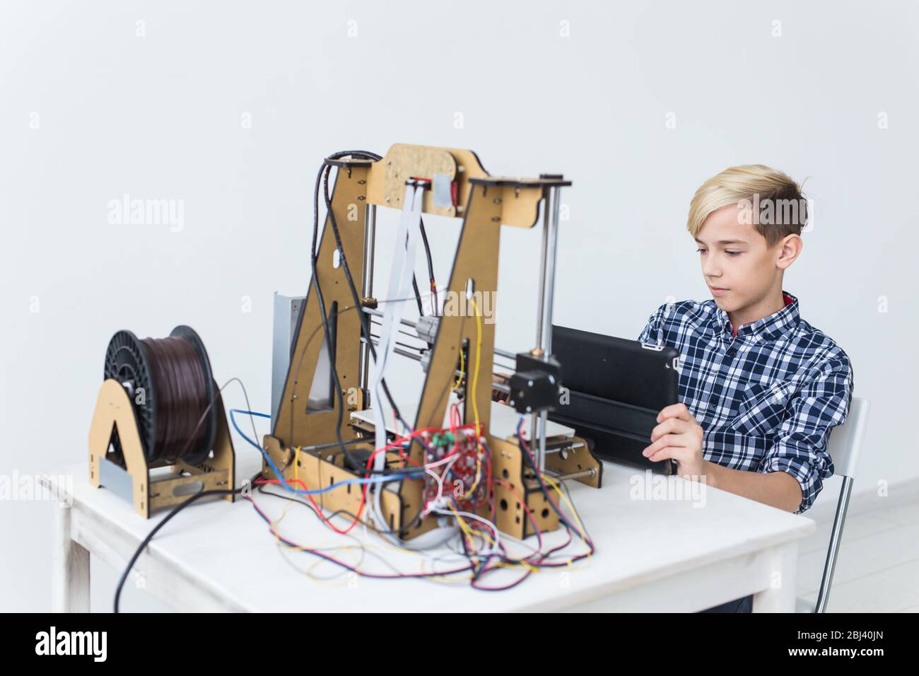 Education, children, technology concept - teen boy is printing on 3d ...