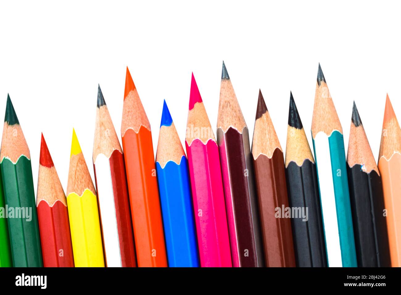 Colored pencil crayons in a row on white background Background