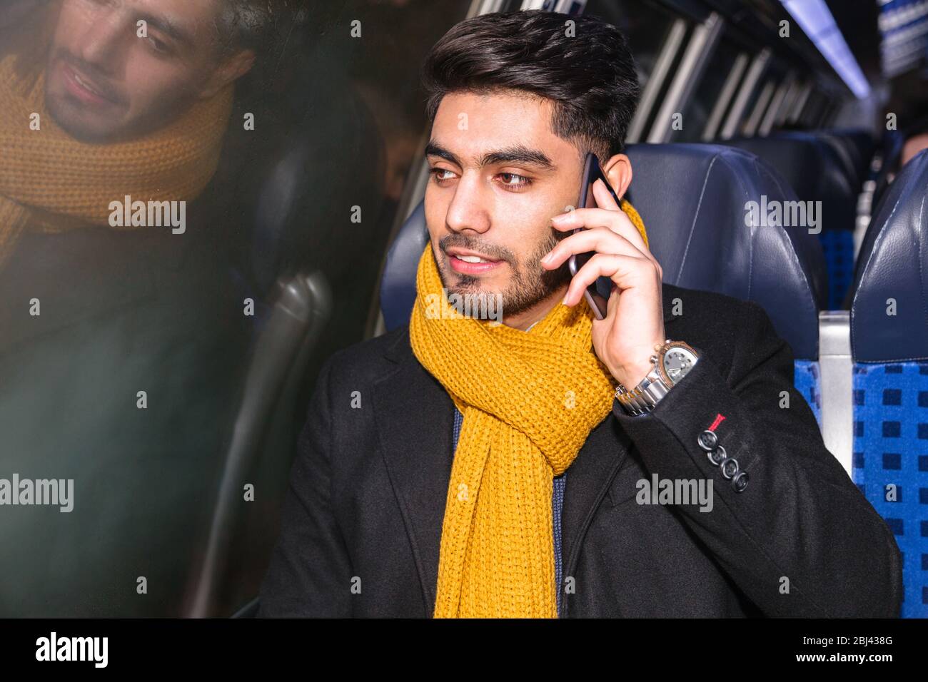 Businessman commuting to work on train using phone Stock Photo