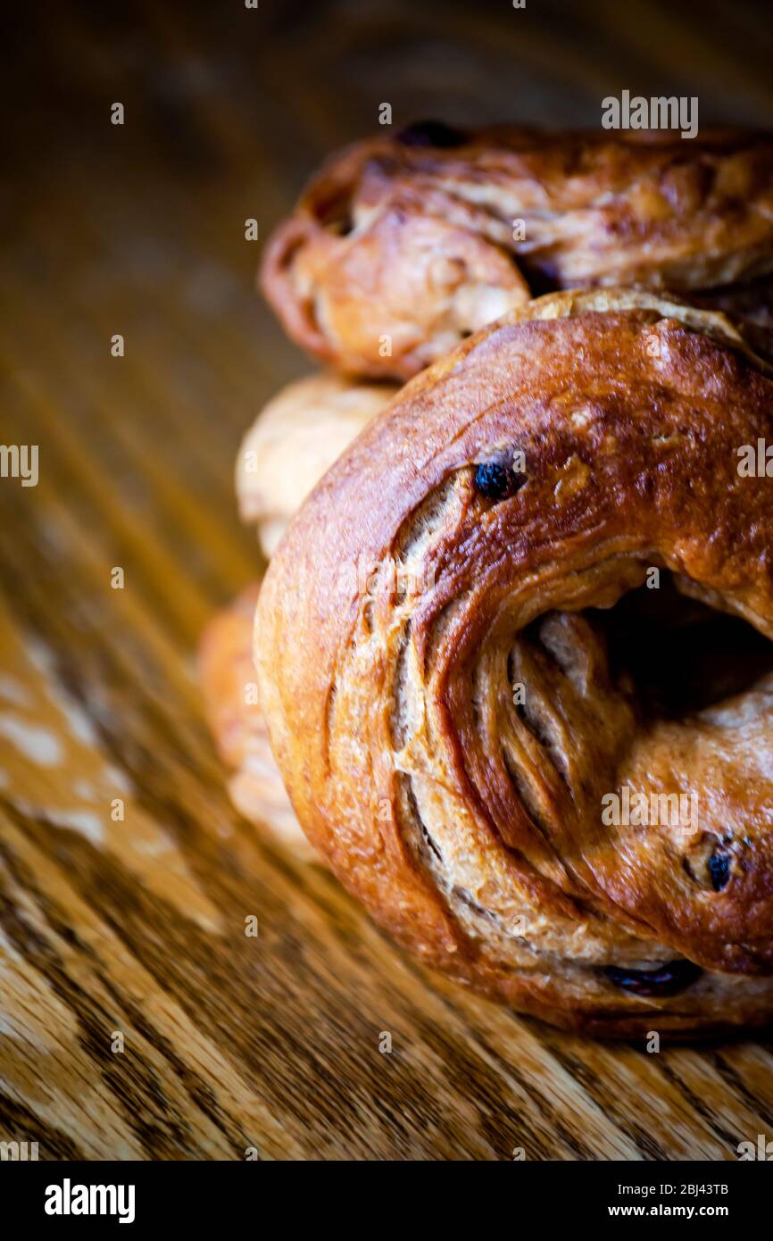 Dramatic lighting on a stack of homemade cinnamon raising bagels.  Close up view, blurry background.  Cropped half view. Stock Photo