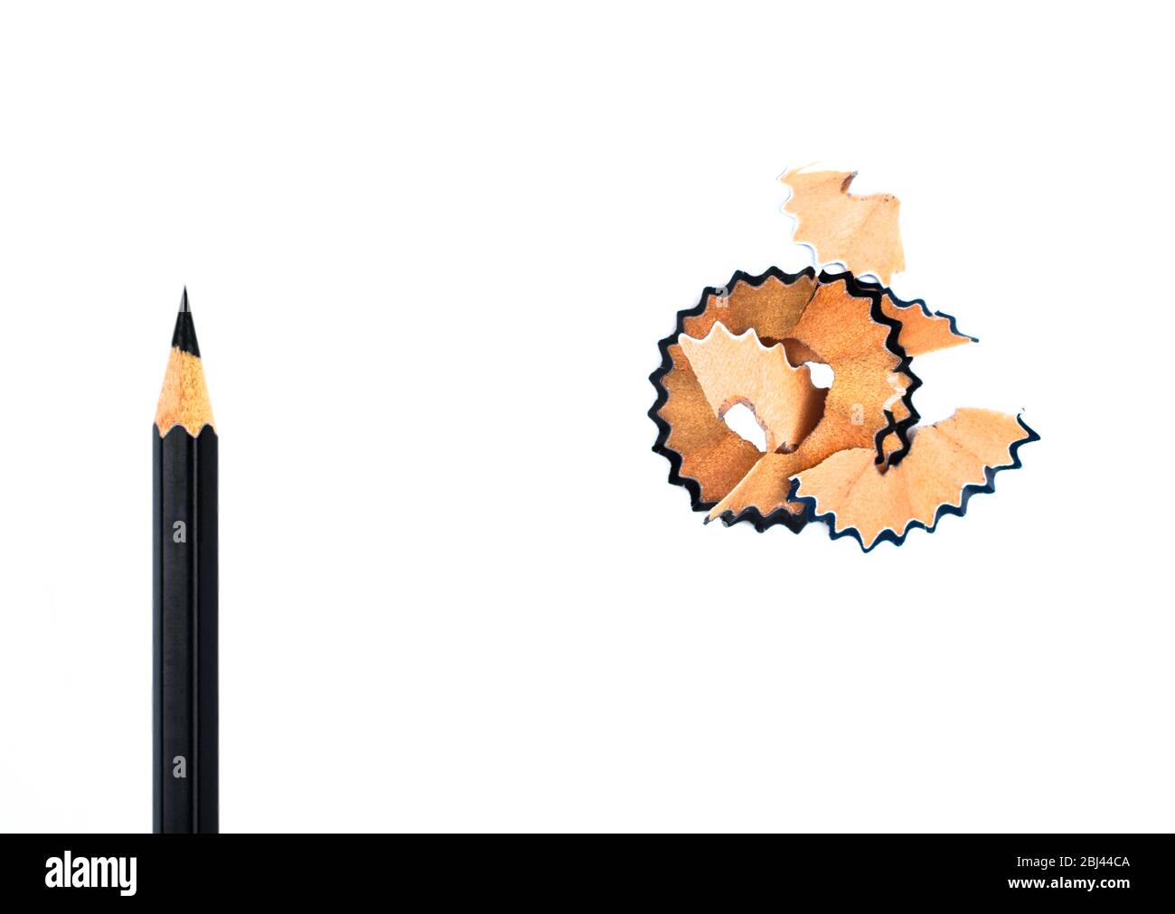 Top view of some pencil shavings placed beside a black color wood pencil crayon Stock Photo