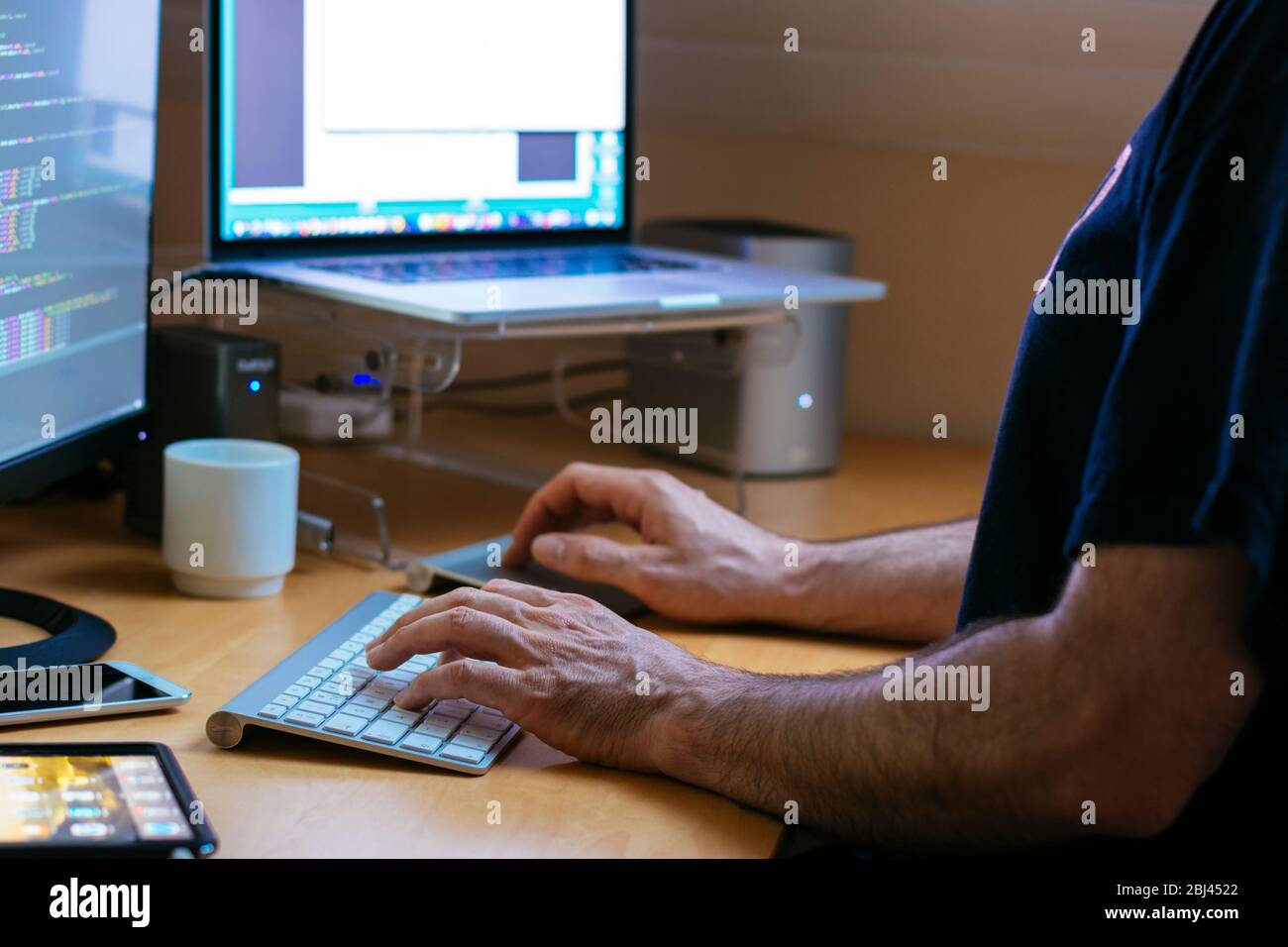 Software developer on keyboard in home office Stock Photo - Alamy