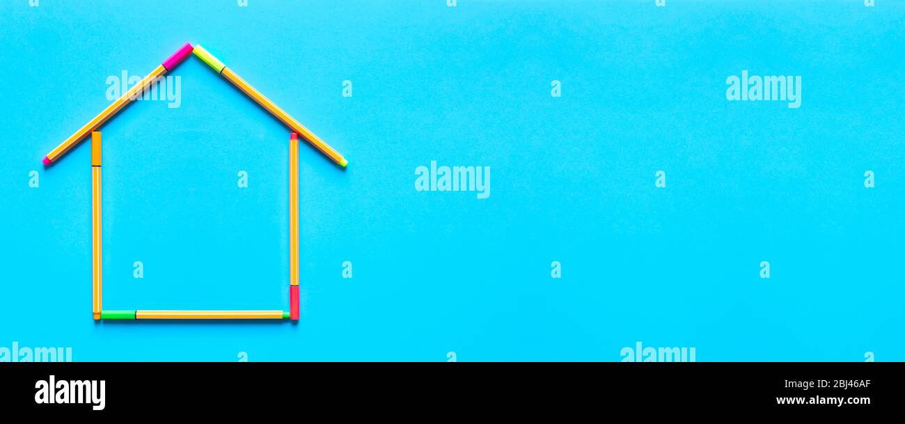 Top panoramic view of fluorescent marker pens forming a drawing of a house on pastel blue background, space for text. Housing concept. Stock Photo
