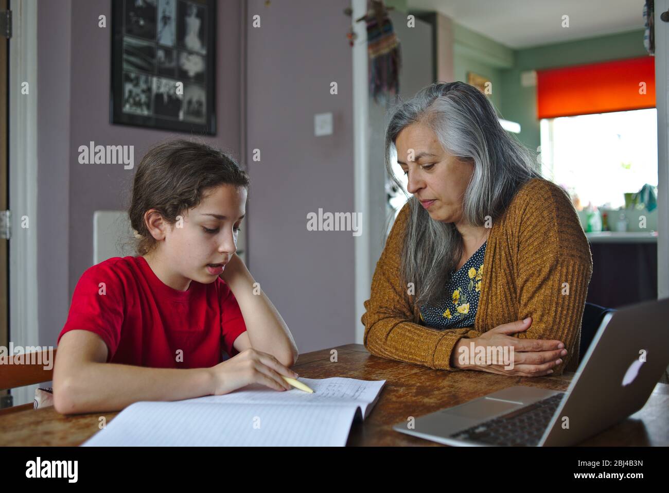 Parent helping child with school work at home during coronavirus lockdown. April 2020 UK Stock Photo