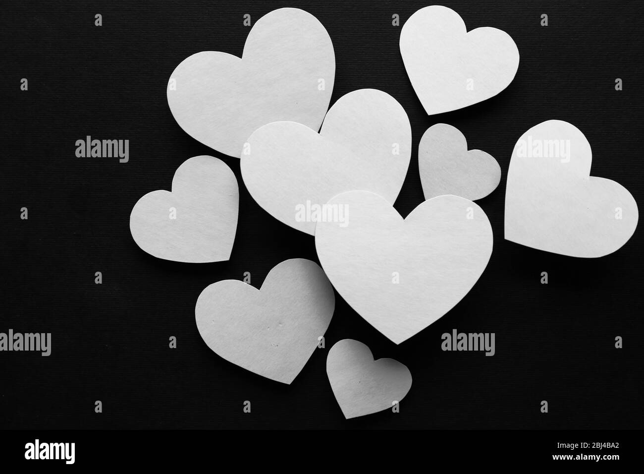 White paper hearts on black background Stock Photo Alamy