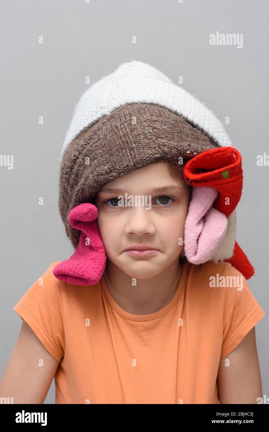 Funny girl put a bunch of things on her head and looks in the frame Stock Photo