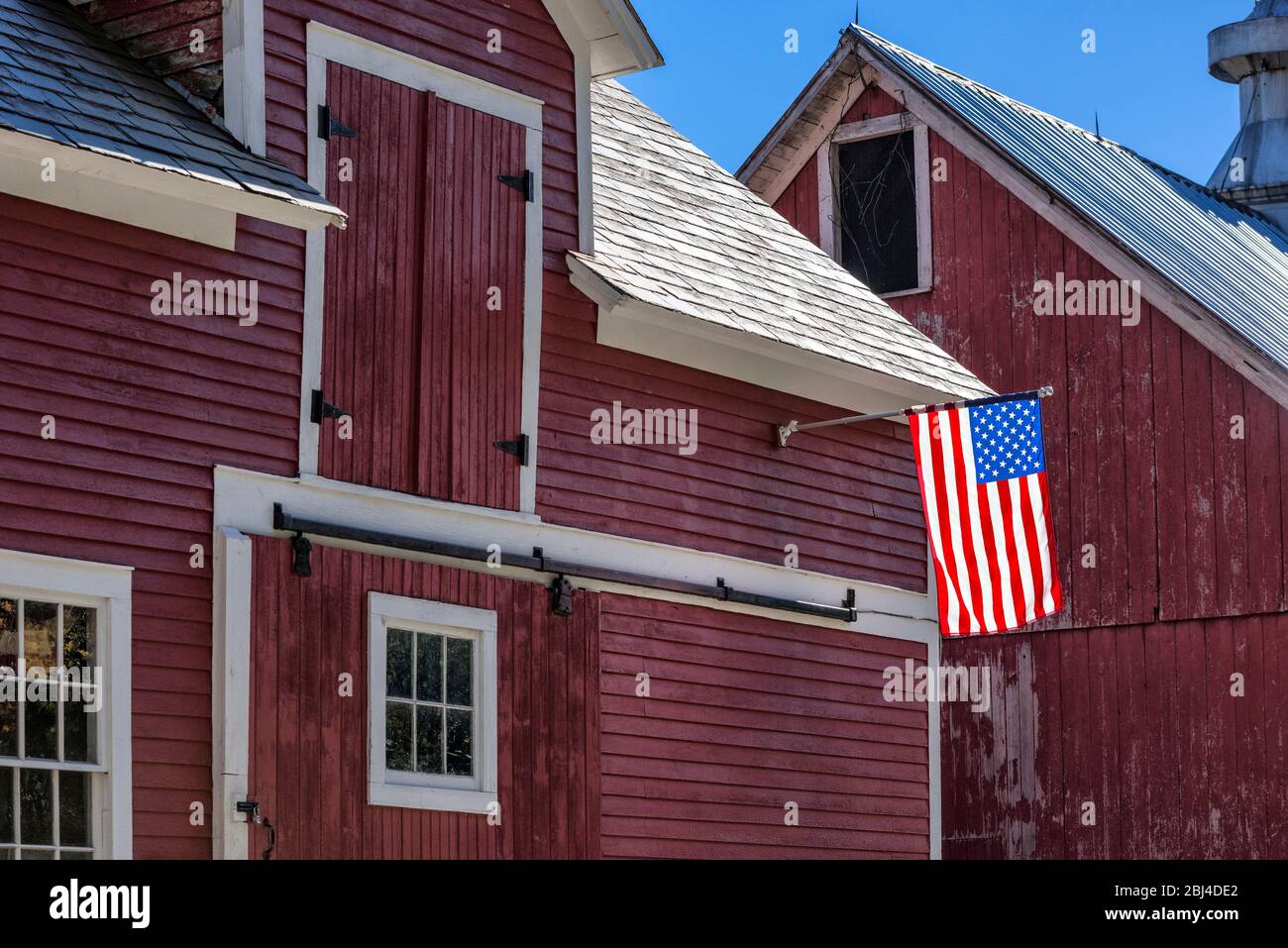 American flag on rustic red barn. Stock Photo