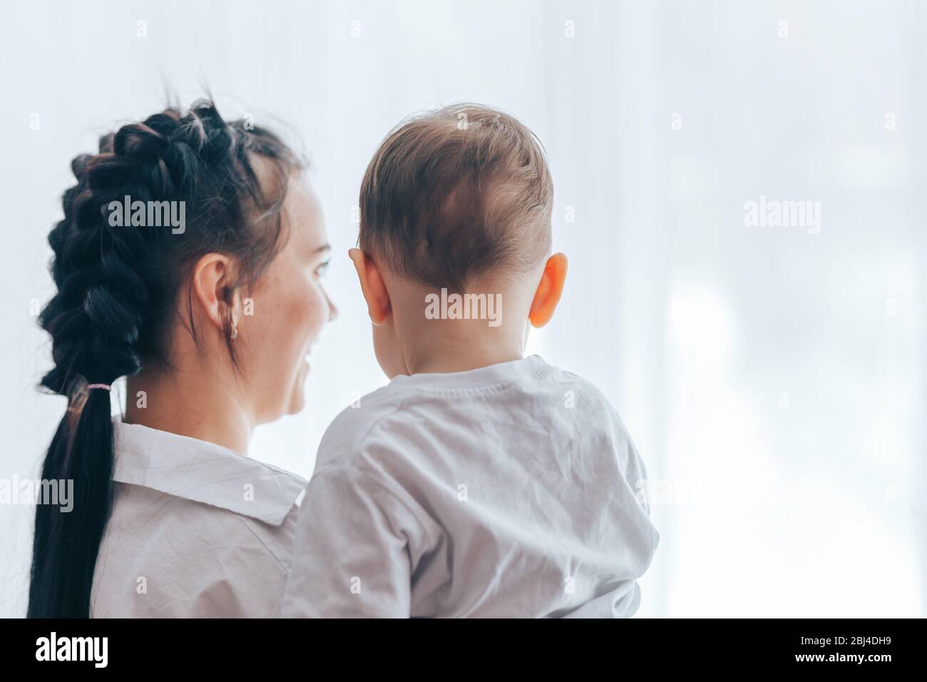 Young mother holding little son in her arms Stock Photo - Alamy
