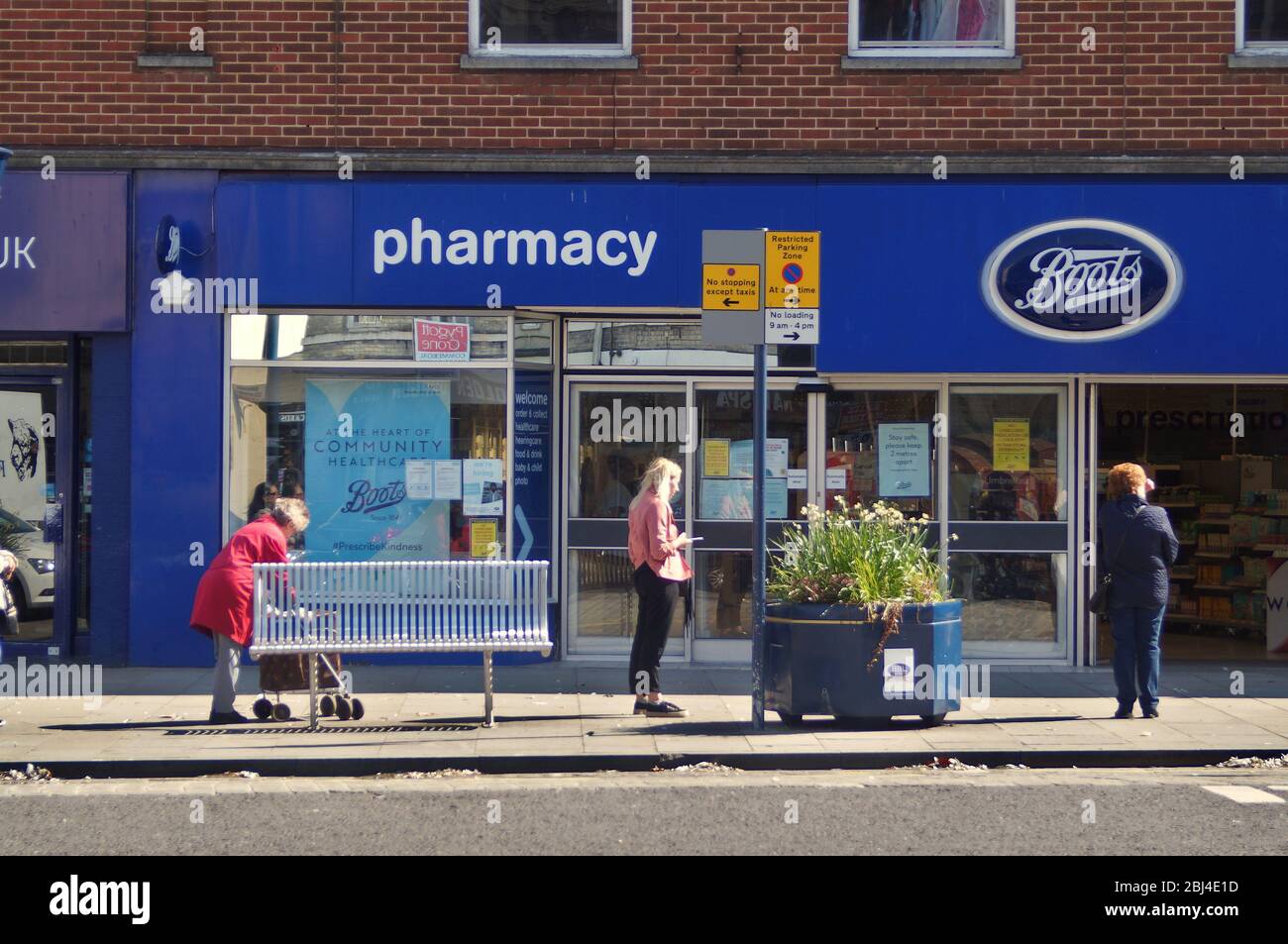 People social distancing  during the COVID pandemic while queuing outside Boots pharmacy in BOSTON Lincolnshire, Stock Photo