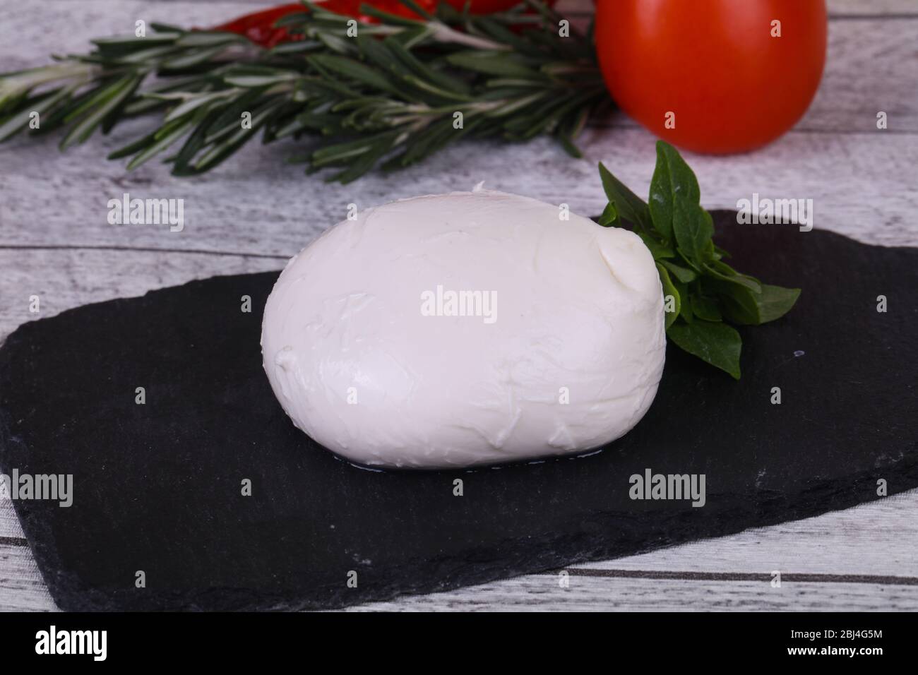 Italian Mozzarella cheese ball served basil and tomatoes Stock Photo