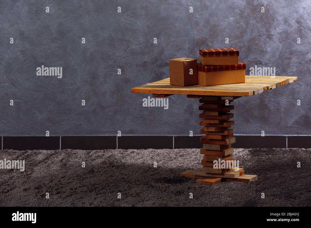 Small wooden table and boxes on grey wall background Stock Photo - Alamy